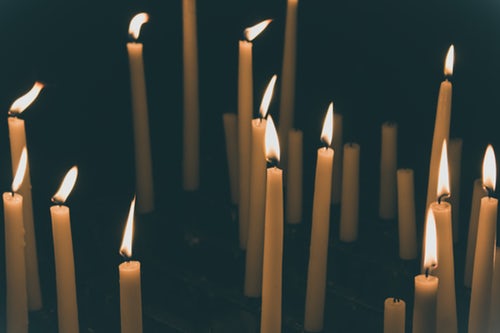 lit pillar candles set against darkness