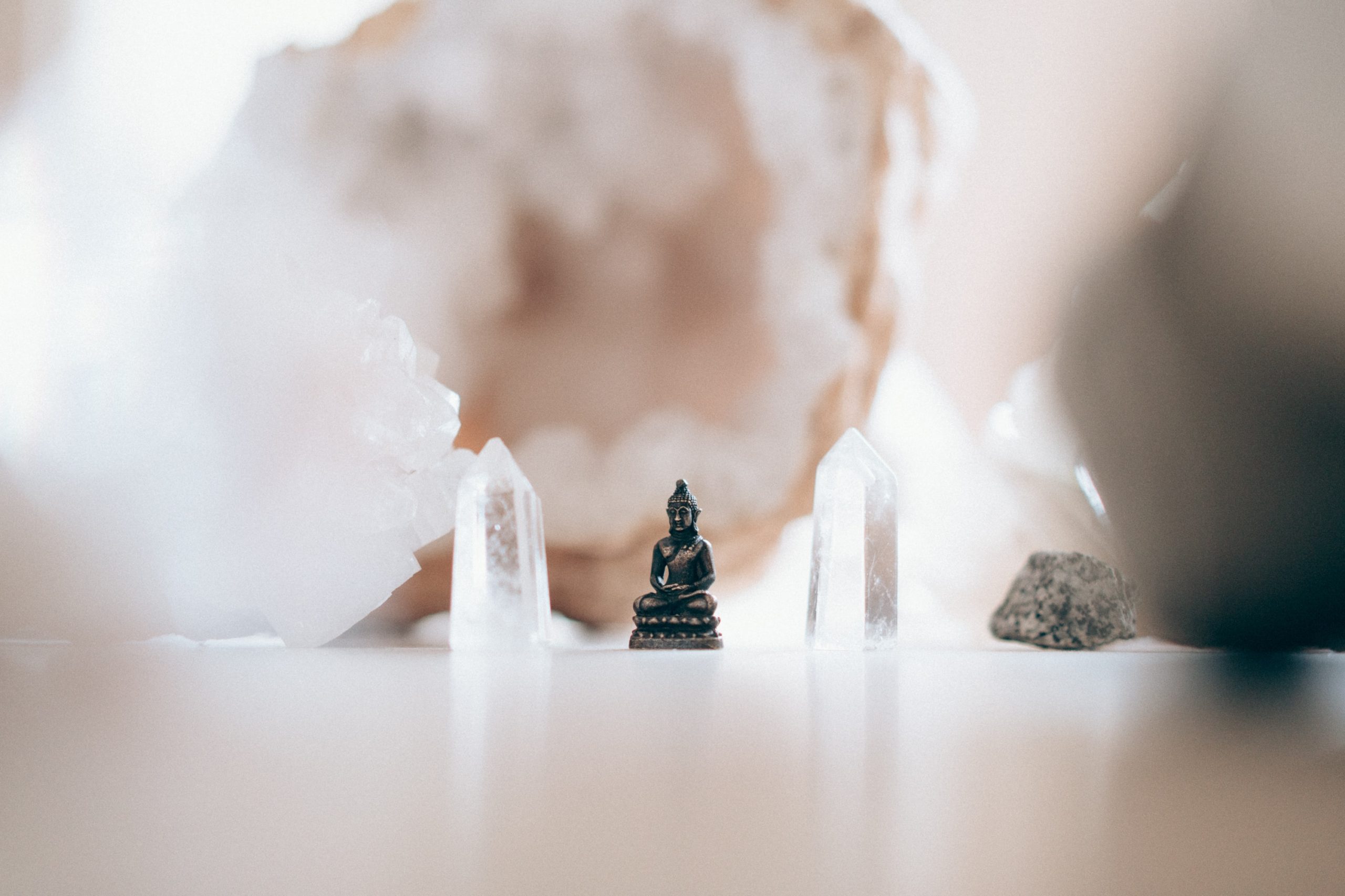 A tiny buddha statue surrounded by quartz crystals